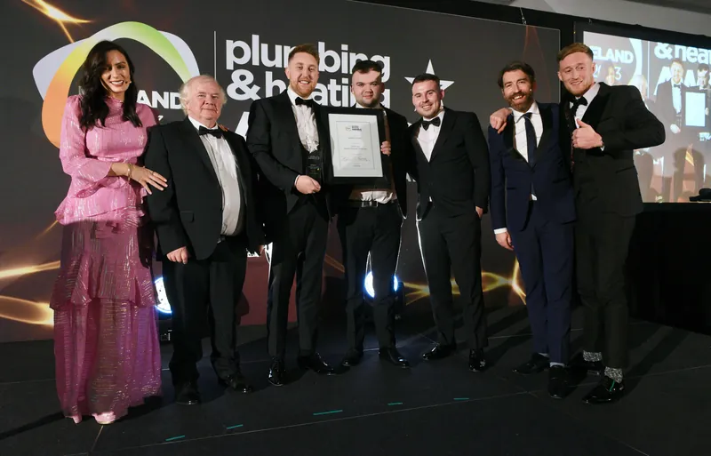 Stephen Lambe and the team on stage with the Ireland's Plumber of the Year certificate, 2023