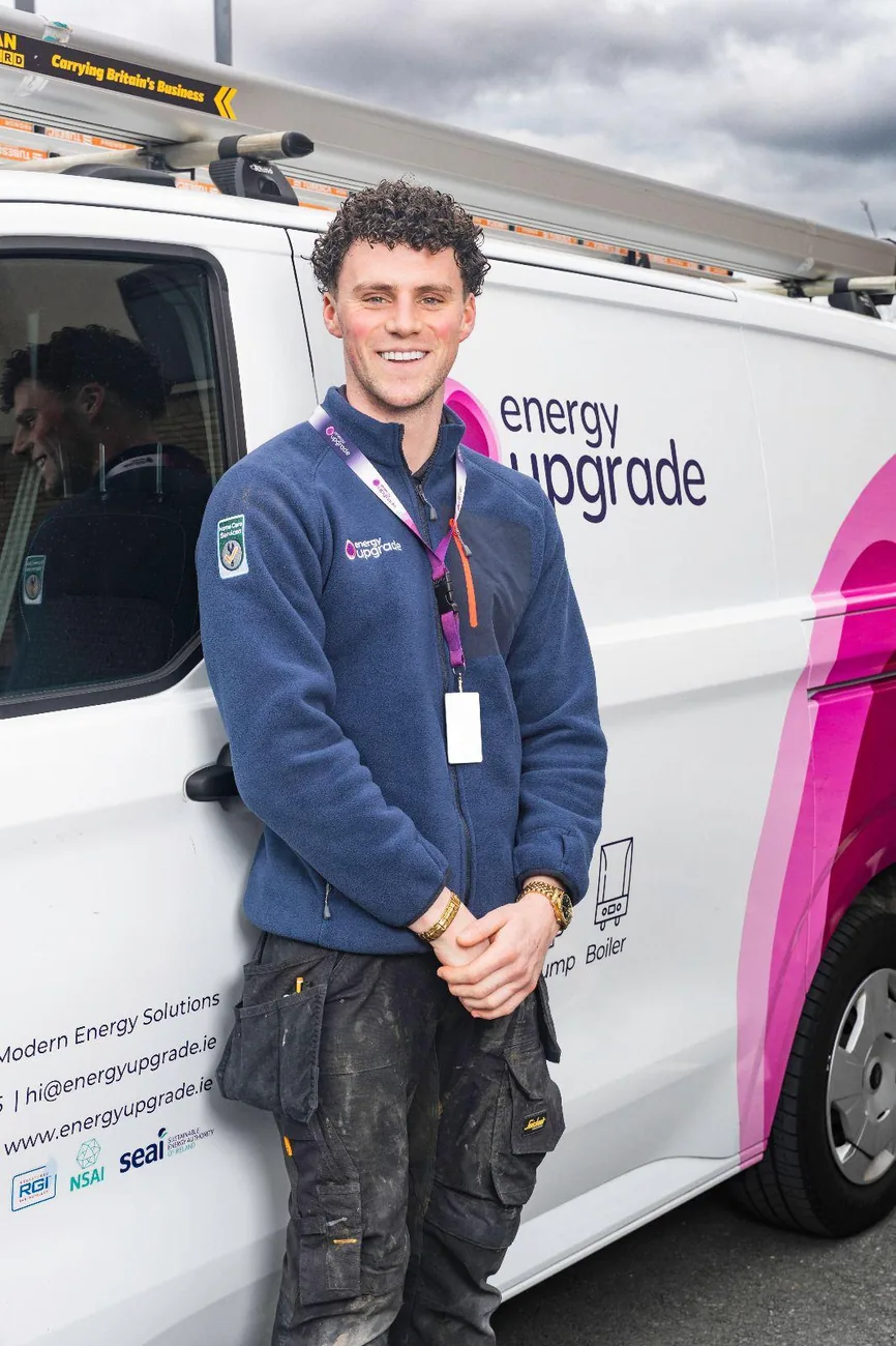 Energy Upgrade engineer smiling by the company van