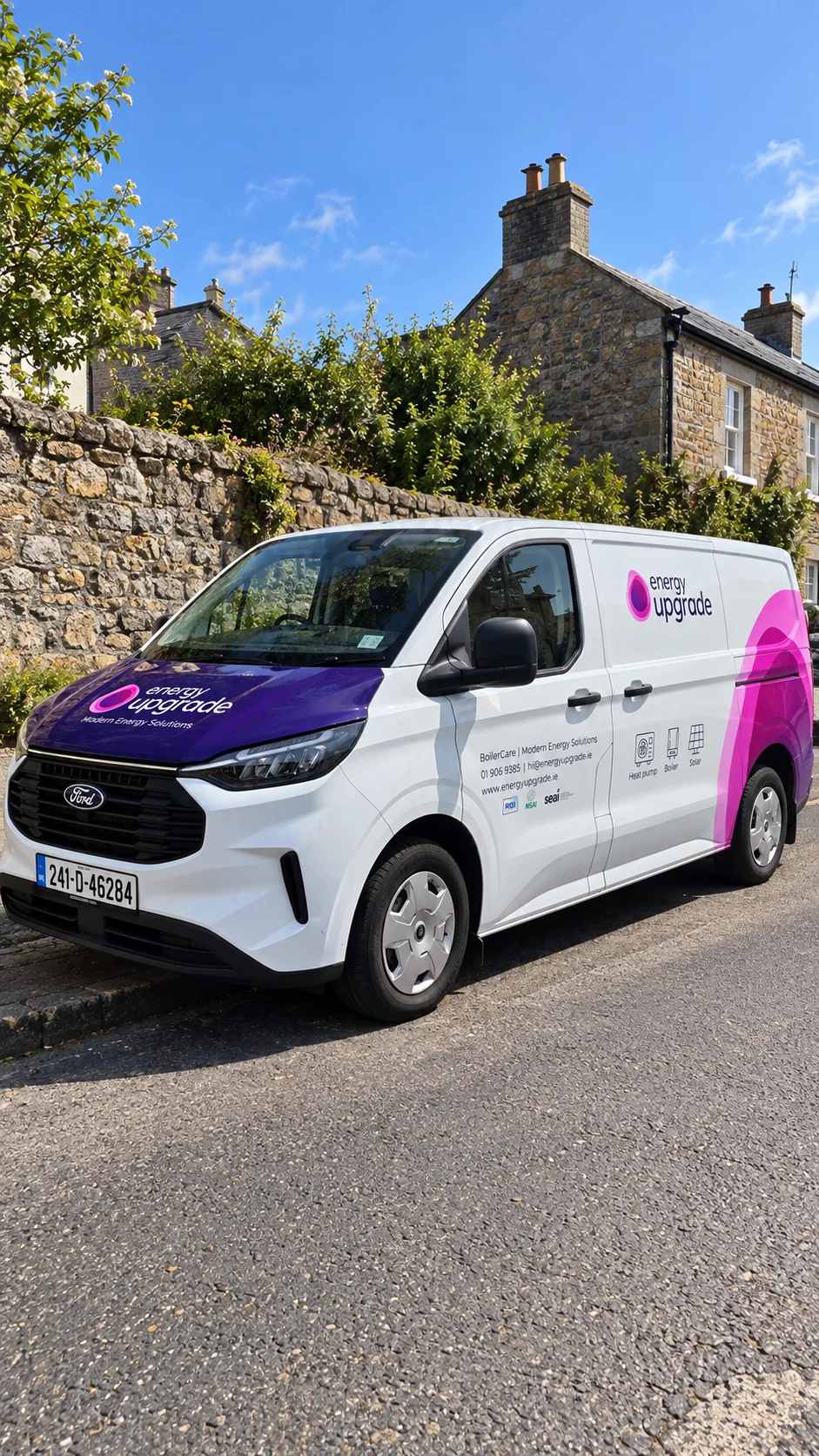 An Energy Upgrade van parked by a stone wall in a village