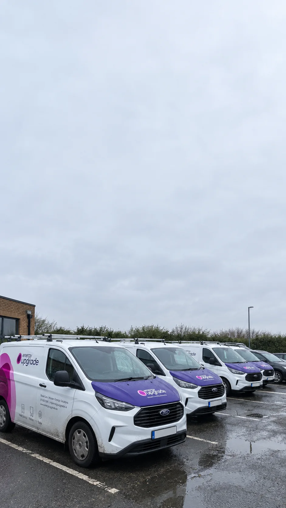 Energy Upgrade vans lined up in the yard